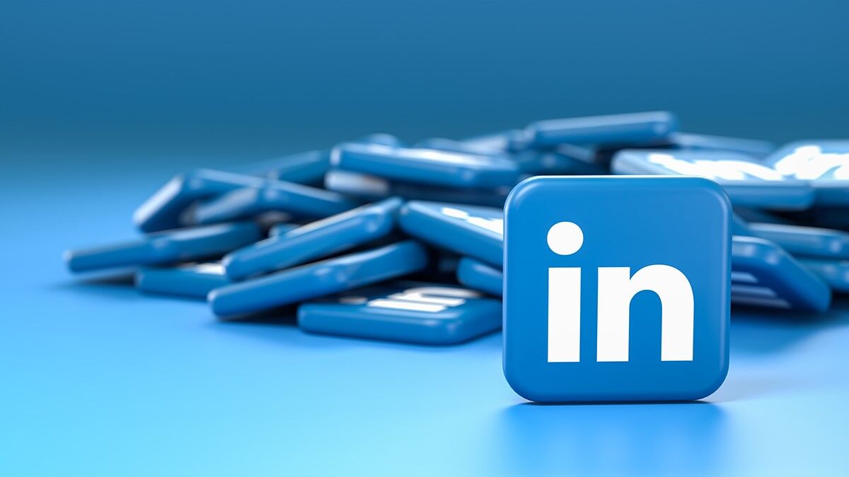 A blue cube in the foreground, emblazoned with the LinkedIn logo in white, is surrounded by several similar cubes scattered on a blue surface. These cubes seem to be buzzing with the energy of a lively sales newsletter.